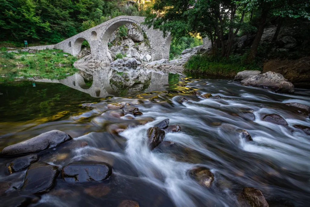 Arched stone bridge over a mountain river in the Rhodopes