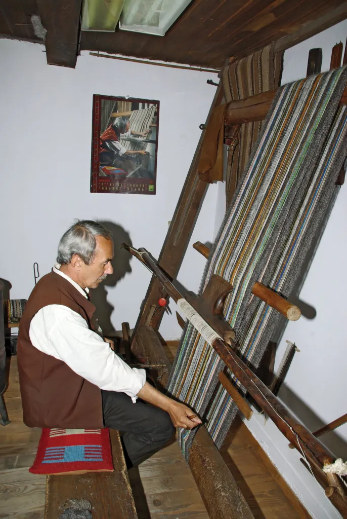A weaver working at a traditional wooden loom